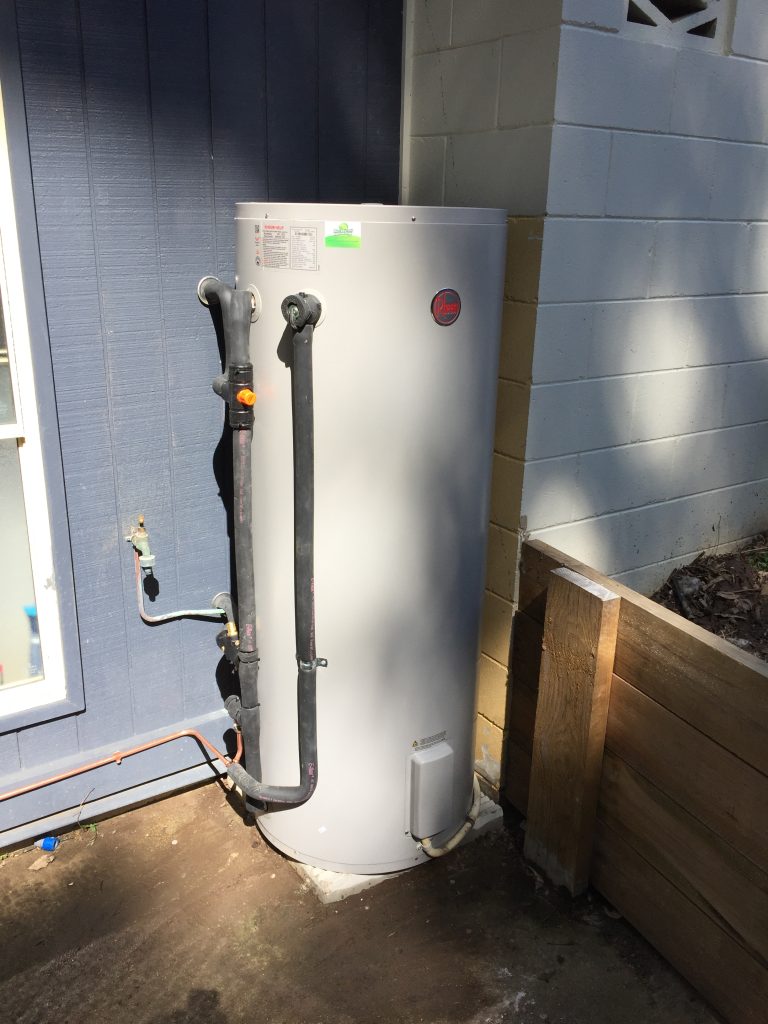 Rheem electric hot water system installed outside a home on the Sunshine Coast by Hot Water Heroes, featuring insulated piping and a secure outdoor setup.
